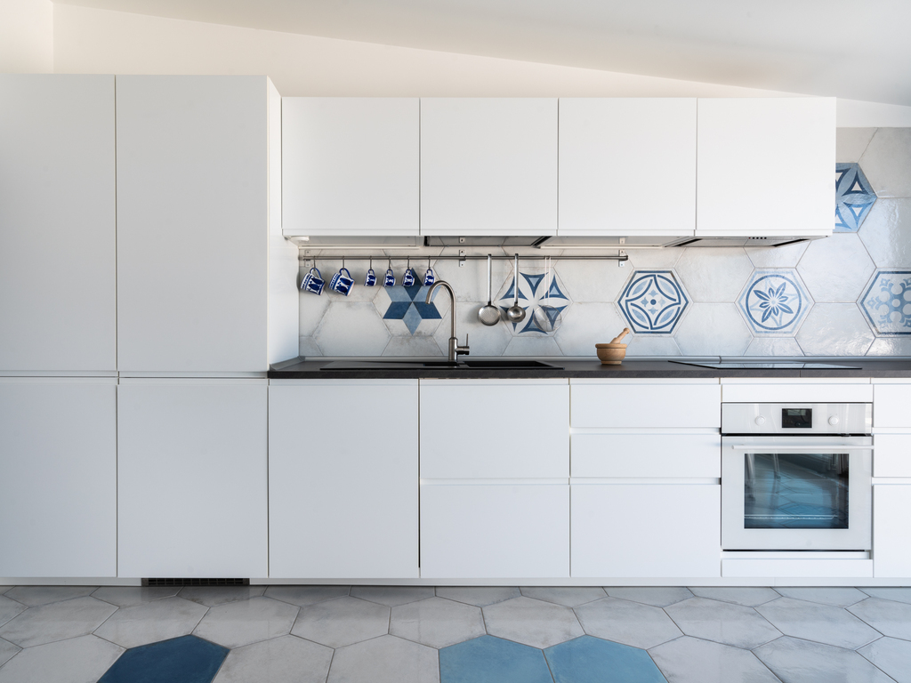 Cucina progettata per l’attico con linee essenziali e integrazione con lo spazio abitativo.