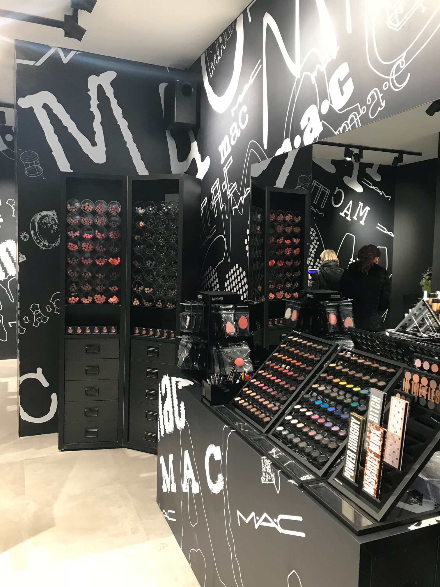 esposizione prodotti MAC su pareti grafiche nere progetto retail Crucitti Architetti