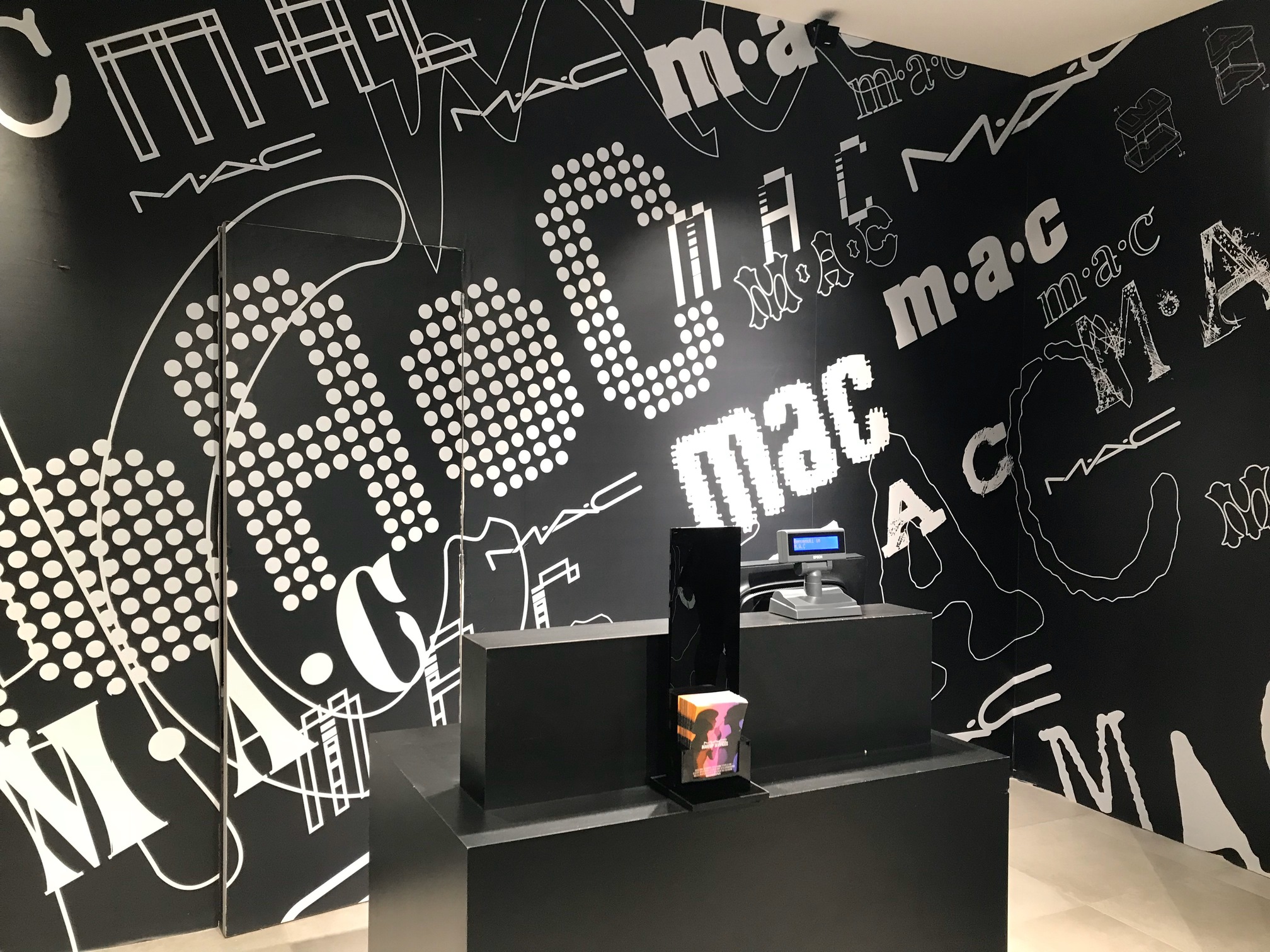 cassa negozio MAC con arredi neri e illuminazione moderna progetto Crucitti