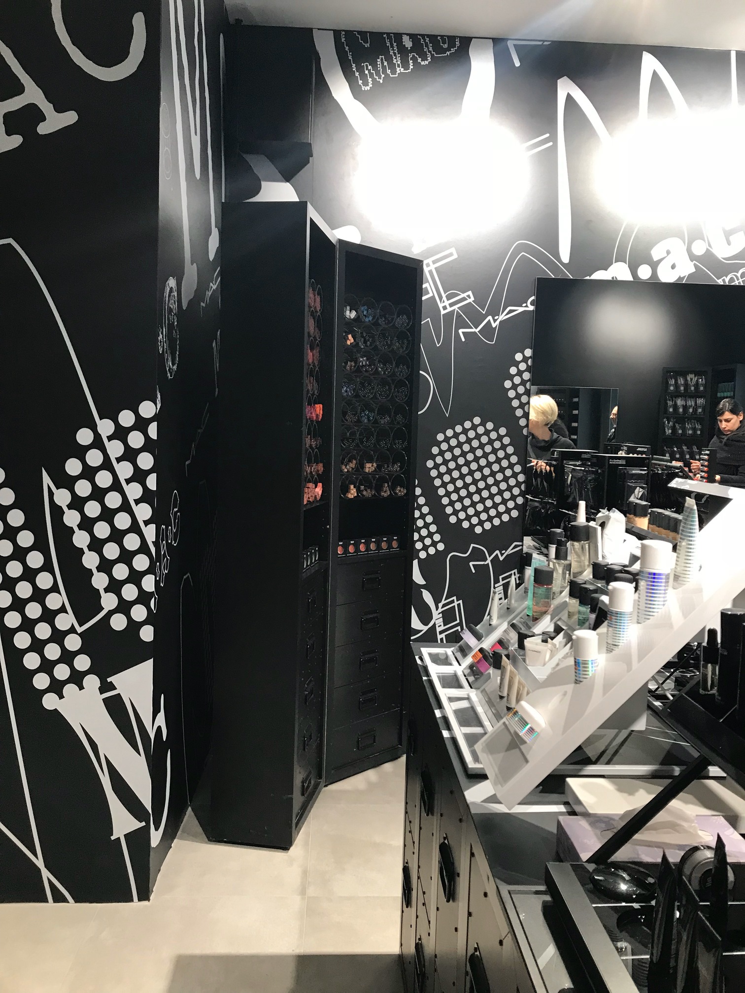 interno negozio MAC con pareti nere e espositori make up progetto Crucitti Architetti